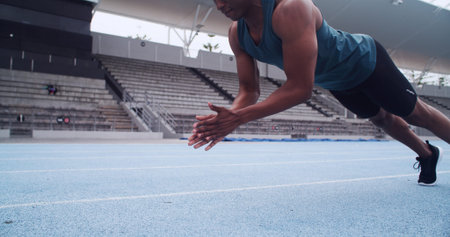 Hands, athlete and push up on track, stadium and clap for coordination, agility or fitness routine....