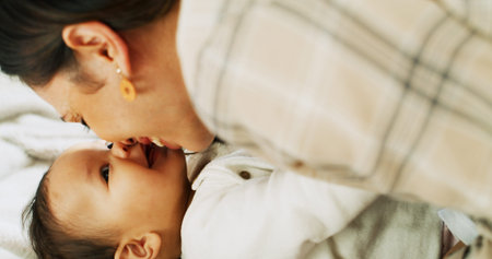 Family, love and mother kiss baby for bonding, healthy relationship and childcare in home. Happy,...