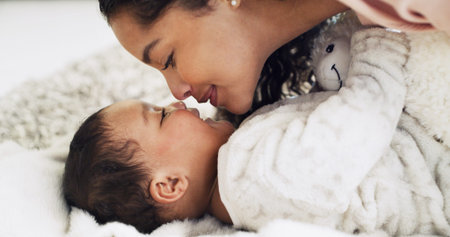 Kiss, bedroom and mom with baby in home for rest, comfortable and relax for bonding. Family, parent...