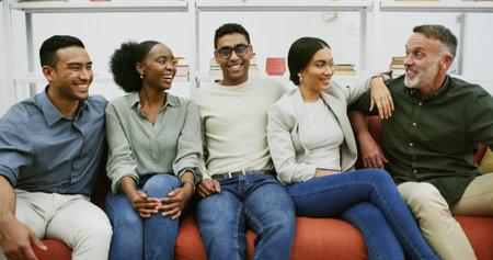 Break, diversity and laughing with business people on sofa in office lounge for bonding or...