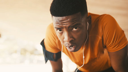 Portrait, black man and breathing with earphones for fatigue, fitness or intense training in city....