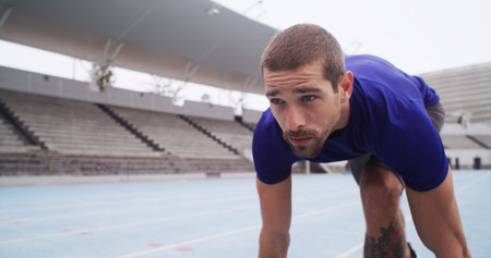 Athlete, man and ready to start on track for cardio workout, marathon training and race at stadium....