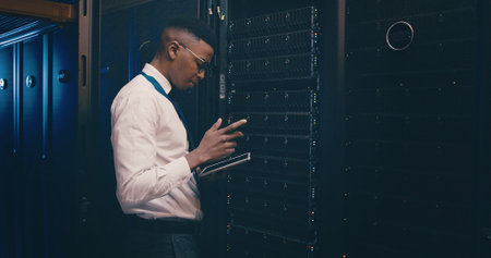 Engineer, black man and reading tablet in server room for cybersecurity, database update and GDPR....