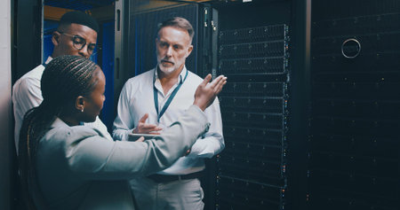 Collaboration, conversation and tablet with people in server room for network administration....