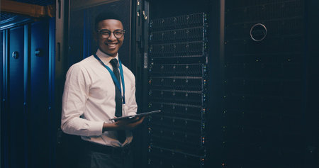 Engineer, black man and portrait with tablet in server room for inspection, system update or happy....