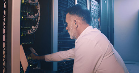 Engineer, laptop and cable connection at data center for network test, troubleshooting or solution....