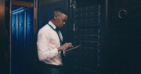 Technician, black man or typing on tablet in server room for system maintenance, update or GDPR....
