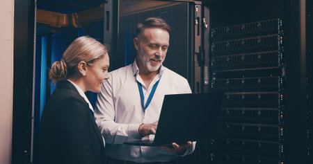 Laptop, discussion and team of engineers in server room for technical support, database or...