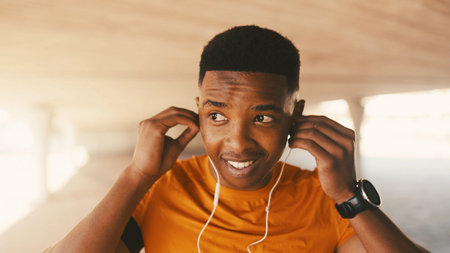 Fitness, earphones and music with black man in city for workout podcast, streaming service and...