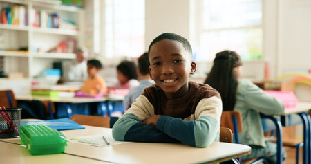 Boy, child and smile in classroom with arms crossed, portrait and confidence for learning at...