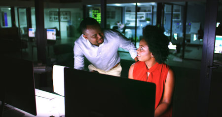 Night, talking and business people on computer in office for finance review, budget planning and...