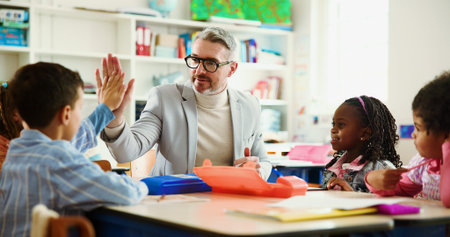 Teacher, child and high five for motivation in classroom with smile, support and education at...