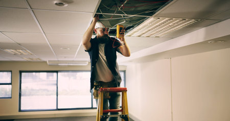 Electrician, ceiling and man in office with wire, test or safety for quality control. Inspect,...