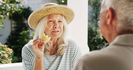 Patio, old couple and bonding with fruit, home or conversation on weekend, wellness or healthy food....