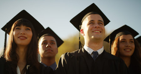 College, students and man with graduation, celebration and ceremony with achievement. Outdoor,...