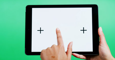 Hands, tablet and blank screen in studio with click, mock up space or ui on green background....