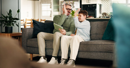 High five, child and dad with tablet, home and bonding in living room, success and education on web....