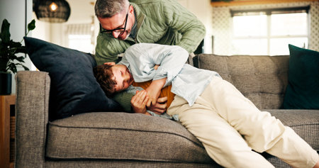 Happy, dad and tickling child in home or playing in living room, family and bonding on break or fun....