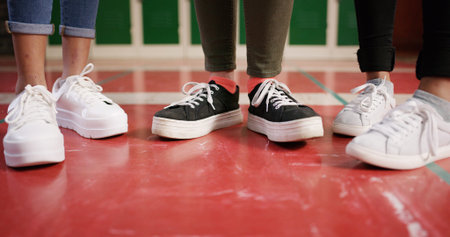 Feet, school and friends with shoes in hallway for education, learning and knowledge. Lockers,...