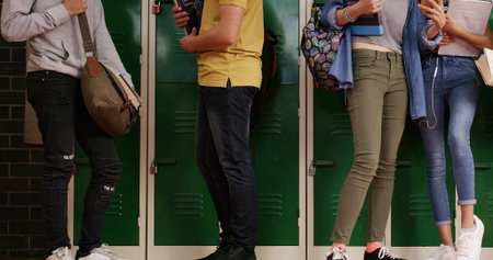 Legs, group and high school kids in corridor with backpack, study and discussion by lockers for...