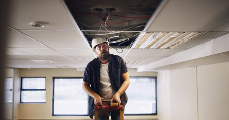Electrician, man and light wires for construction, remodeling project or renovation for office....