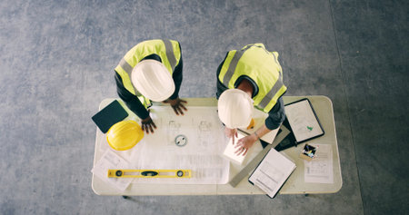 Blueprint, tablet screen and architecture with people and documents for discussion, engineering and...
