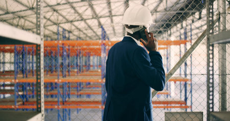 Man, phone call and talk at storage plant, inspection and report with back at industrial warehouse....