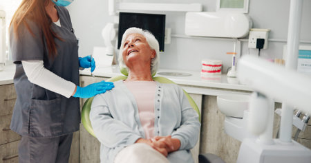 Dentist, consultation and senior woman in office, conversation and teeth whitening. People, doctor...