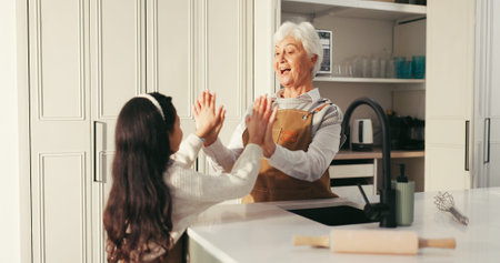 Happy grandma, grandchild and high five in kitchen for baking success or dessert recipe in home....