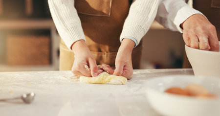 Hands, parent and kid with baking dough in home for cookies, learning and development. Family,...