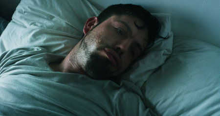 Insomnia, mental health and man with depression in bed, anxiety and lonely in home. Thinking, grief...