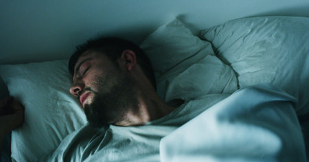 Tired, man and sleeping on bed at house with nightmare, depression and mental exhaustion. Fatigue,...