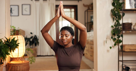 Black woman, yoga and namaste hands in living room for mind body connection, meditation and relax....