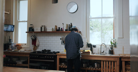Back, cooking and man in kitchen with meal prep, ingredients and organic cuisine for vegetarian. Salad recipe, chef or person in home with vegetable dish, healthy food or nutrition for natural diet.の写真素材