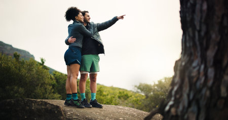 Hiking, pointing and travel with couple in nature for trekking adventure health journey and support. Sightseeing, environment and explore with man and woman on path outdoor for bonding and workoutの写真素材