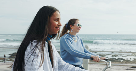 Friends, cycling and women by ocean for travel on summer holiday, vacation and weekend together....
