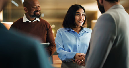 Handshake, meeting and smile with business people in office at night for feedback success. Tablet,...