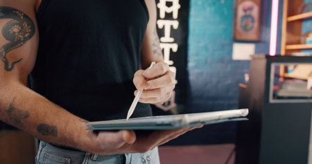 Drawing, hands and tablet with man in tattoo parlor for artistic design or creative planning. App, pen and small business with illustrator person in studio for ink or process of body art developmentの写真素材