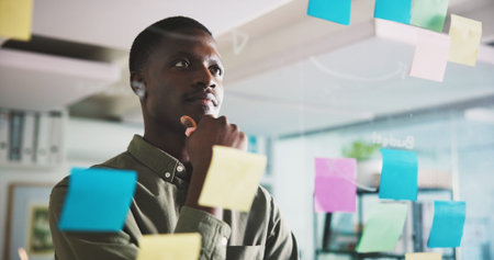 Thinking, brainstorming and man in office with sticky notes, ideas or solution for project...