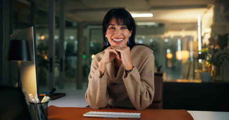 Woman, smile and portrait at night in office for overtime, deadline and career at media company. Person, journalist and happy with confidence, writing or editing job in dark at agency in Portugalの写真素材