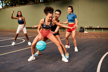 Fitness, basketball and women playing game together for competition, challenge and fun on playground. Outdoor, performance and girl friends on court with ball, exercise and teamwork at sports club.の写真素材