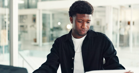 Reading, paper and black man in office with laptop, review or presentation prep on company...