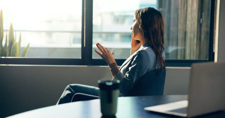 Phone call, window and businesswoman in office with networking, contact or communication for finance. Cellphone, professional and female financial director on mobile discussion for deal in workplace.の写真素材