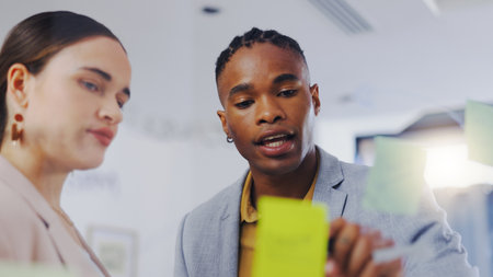 Board, explain or business people teamwork, communication and collaboration on development strategy ideas. Sticky note, brainstorming planning or diversity team cooperation on sales research forecastの写真素材