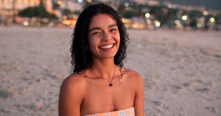 Happy, travel and portrait of woman on beach for tropical vacation, getaway or holiday. Smile, outdoor and female person from Mexico by ocean for seaside weekend trip with peace and calm in evening.の写真素材
