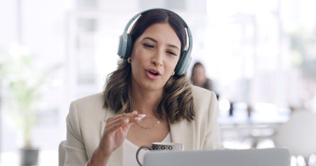 Headphones, laptop and virtual meeting with business woman in coworking office for development...