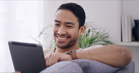 Smile, man and relax with tablet at house for browsing website, social media and movie choice....