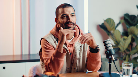 Explain, microphone and podcast with man in studio for broadcast, interview or live streaming. Had gesture, radio and talk show with presenter in production office for subscription entertainmentの写真素材