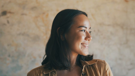 Happy, thinking and woman in home in morning for reflection, thoughtful and wondering. House, wall background and person with smile, relax and confident for daydreaming, nostalgia and calm on weekendの写真素材