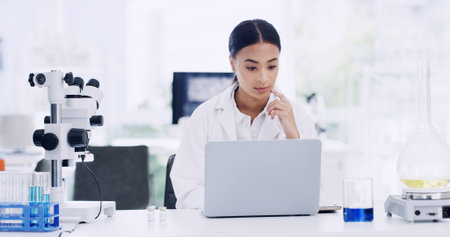 Laptop, woman and scientist in laboratory for medical project, research or healthcare innovation. Science, reading and female biologist with clinical trial for pharmaceutical development on computer.の写真素材